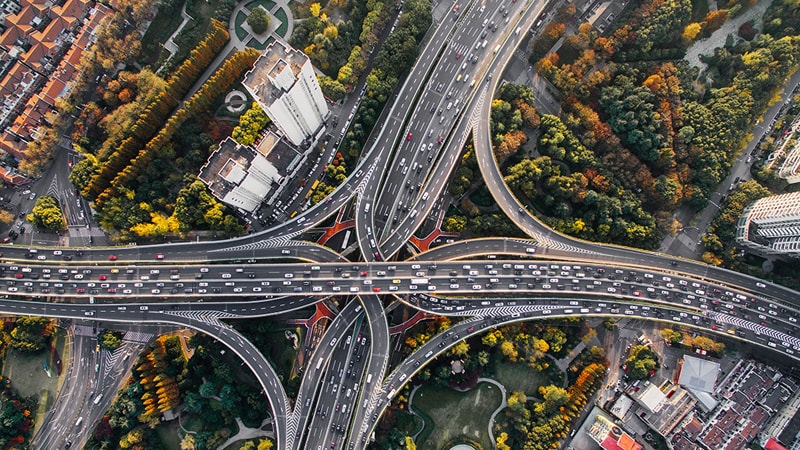 Aerial image looking down on a highway interchange with multiple roads going underneath within a city